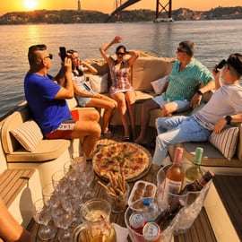 Accogliente crociera in barca al tramonto a Lisbona con open bar e pizza