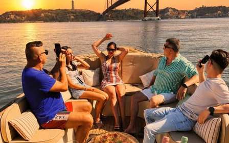 Accogliente crociera in barca al tramonto a Lisbona con open bar e pizza