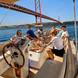 Accogliente crociera in barca al tramonto a Lisbona con open bar e pizza
