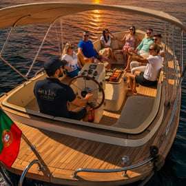 Accogliente crociera in barca al tramonto a Lisbona con open bar e pizza